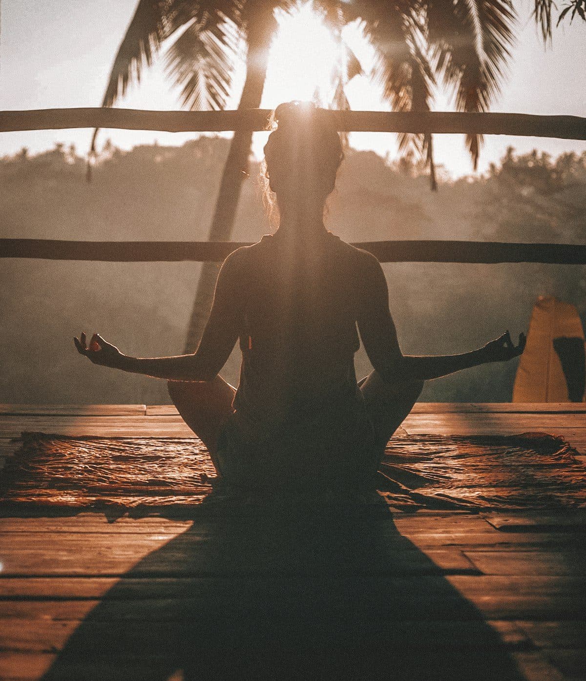 Silhouette en méditation sur un ponton au coucher du soleil
